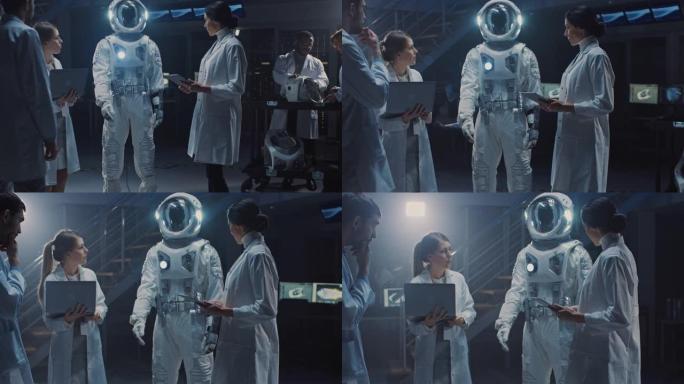 航空工程师团队设计了适合星系探索和旅行的新型太空服。一群穿着白大褂的科学家进行讨论，使用计算机。建造
