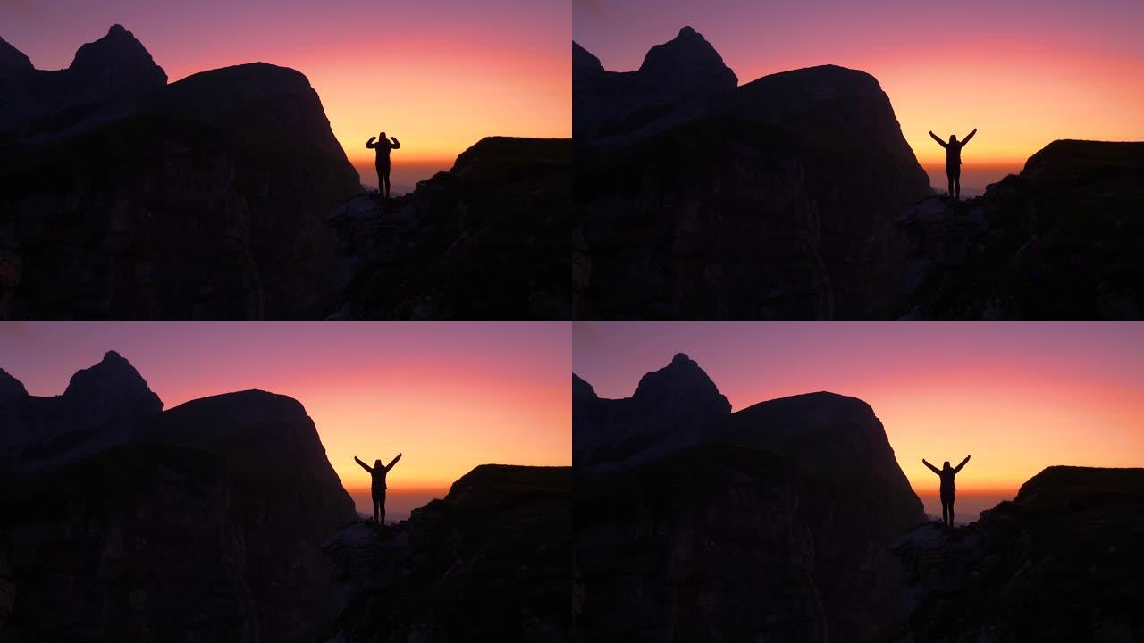 剪影: 金色的夕阳照亮了庆祝登顶的女人。