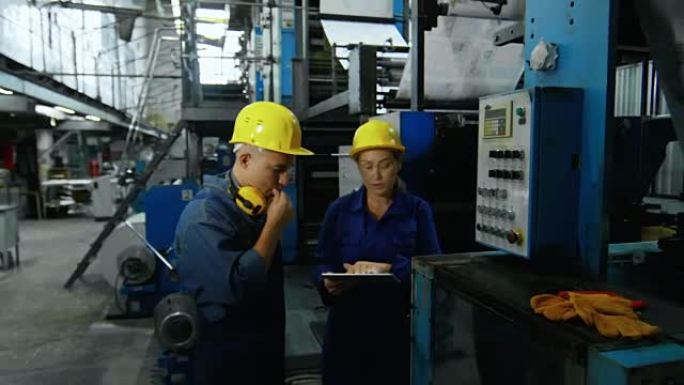 向员工展示工厂机器的女人