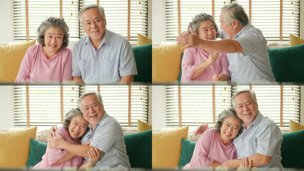 亚洲老年夫妇在客厅里一起激动地看电视电影。人们有放松、老年、退休、老年生活方式的家庭观念。