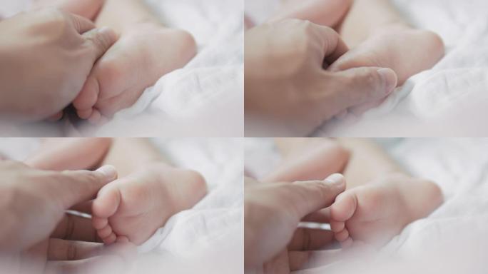 4k特写父亲用手抚摸家里白色床上的小婴儿脚。爱与关怀