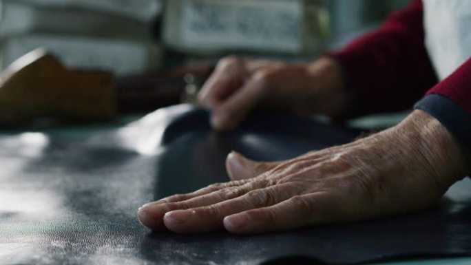 一位鞋匠在一家鞋厂工作，他正在使用意大利传统。
