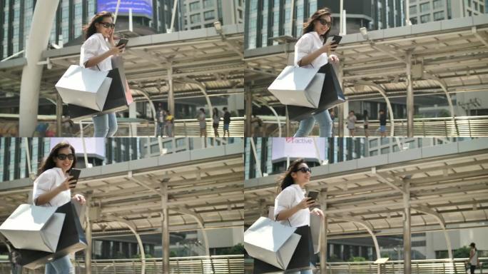 女子在城市里拿着购物袋购物后散步