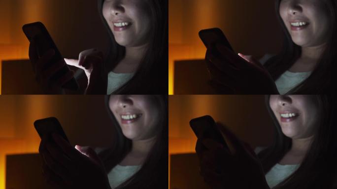 亚洲女性晚上在床上使用智能手机