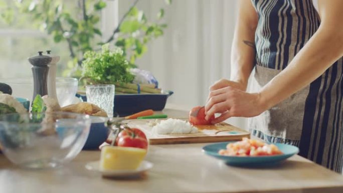 一个男人用锋利的菜刀切碎西红柿的特写镜头。在现代厨房准备健康的有机沙拉餐。天然清洁饮食和健康的生活理