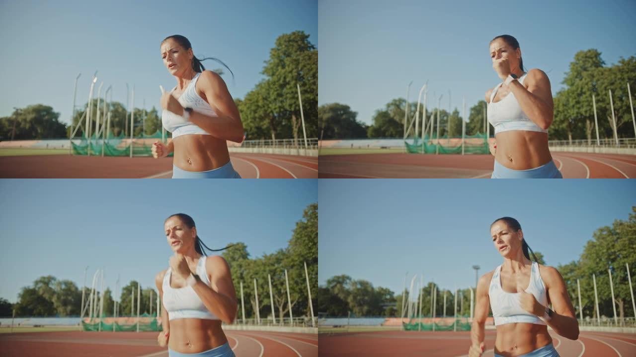 在体育场慢跑的浅蓝色运动上衣中，一位美丽的健身女子的特写肖像照片。她在一个温暖的夏日跑步。运动员在赛