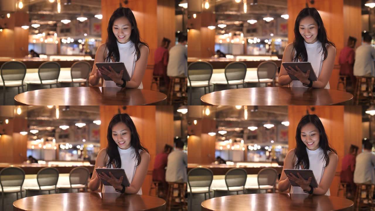穿着休闲服装的亚洲女性使用数字平板电脑