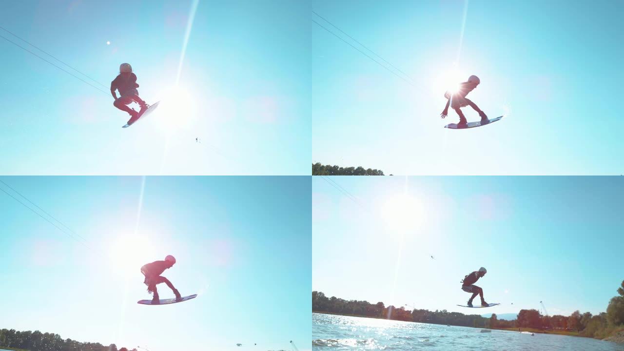 镜头耀斑: 运动男子在湖上醒来时在空中旋转。
