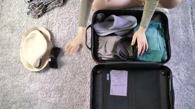 女人把衣服放在手提箱里