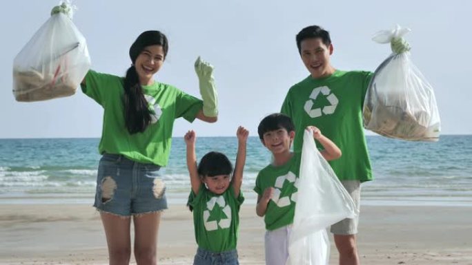 集体幸福的志愿者家庭，在海滩上清理垃圾袋。志愿，慈善，人和生态理念。志愿精神