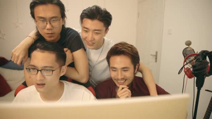 年轻的亚洲音乐家一起使用桌面编辑音乐