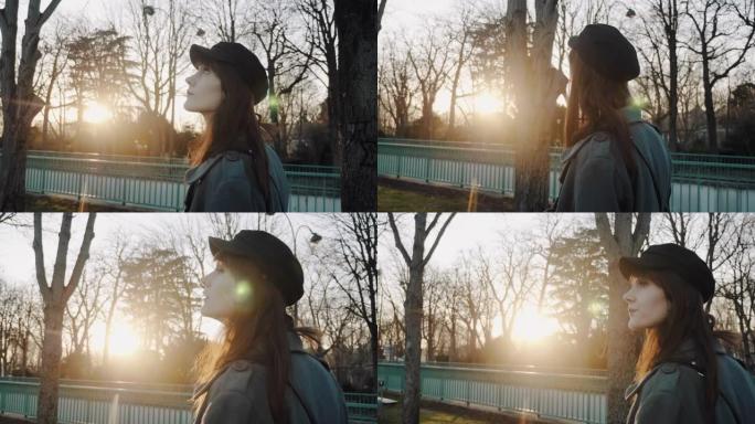 电影的侧视图，优雅的美女沿着日落秋公园散步，享受放松时间的慢动作。