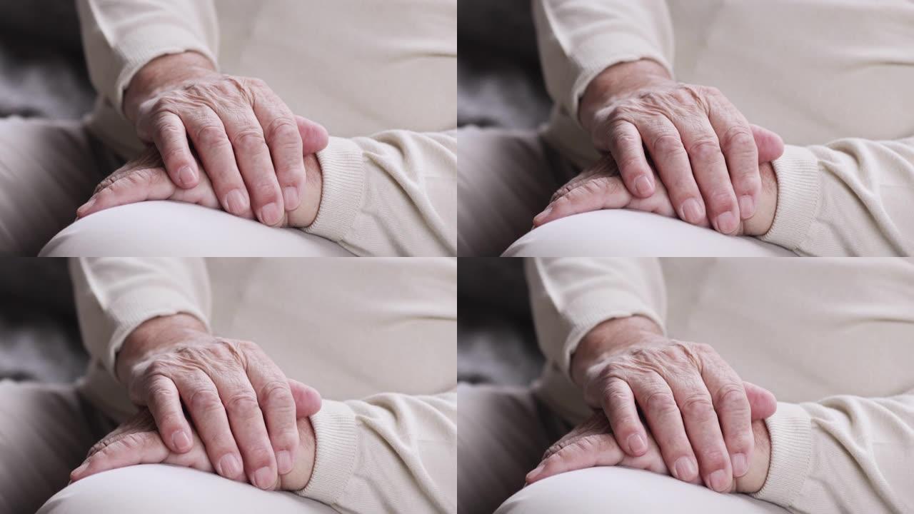 特写聚焦成熟的老年男性折叠起皱的手。
