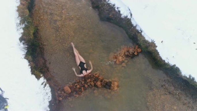 穿着泳衣的女士在冰岛雪中的温泉中放松