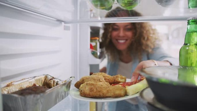 当女人开门时，从装满外卖食品的冰箱里眺望