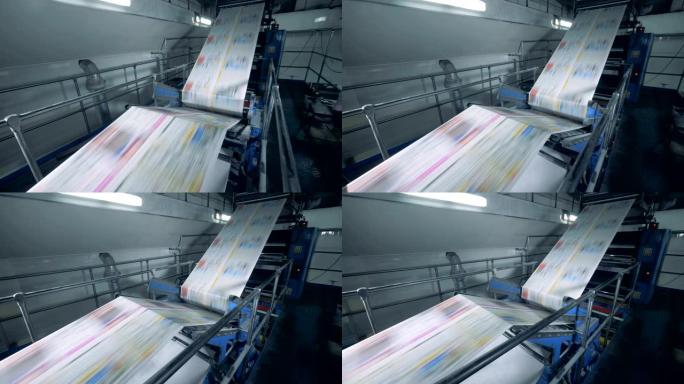 彩色报纸在印刷传送带上移动，现代技术。