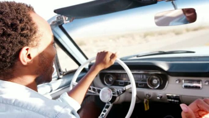 黑人在沙漠高速公路上驾驶敞车，特写