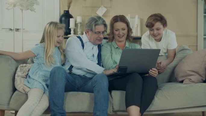 祖父母正在与孙子一起浏览笔记本电脑