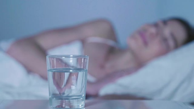 在睡觉前的卧室里，泡腾片会溶解在一杯水中。