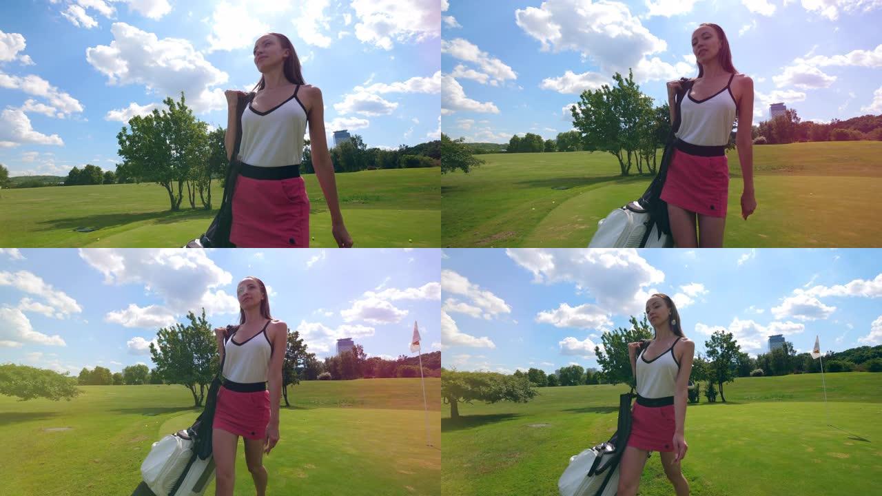 年轻女子拿着一个装有装备的袋子走在高尔夫球场上。