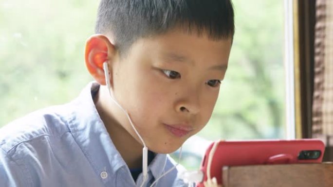 亚洲男孩用智能手机在线学习