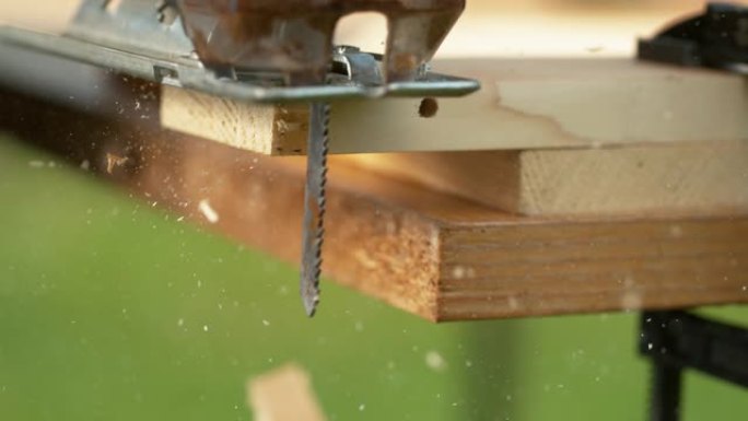 宏观: 当拼图切入工件时，锯末会从金属刀片上飞出。