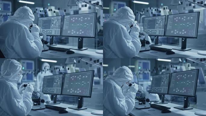 研究工厂洁净室: 工作服的工程师和科学家团队在计算机上工作，使用显微镜检查主板微处理器，开发医疗电子