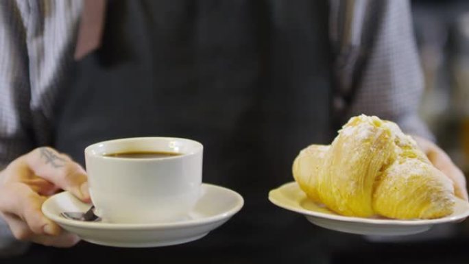 纹身咖啡师展示一杯美式羊角面包