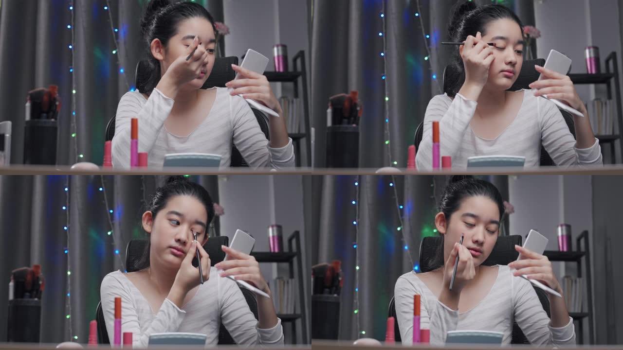 年轻的亚洲有影响力的女孩视频博客演示如何用美容化妆品化妆。她在家里的客厅里用相机记录在线辅导班。社交