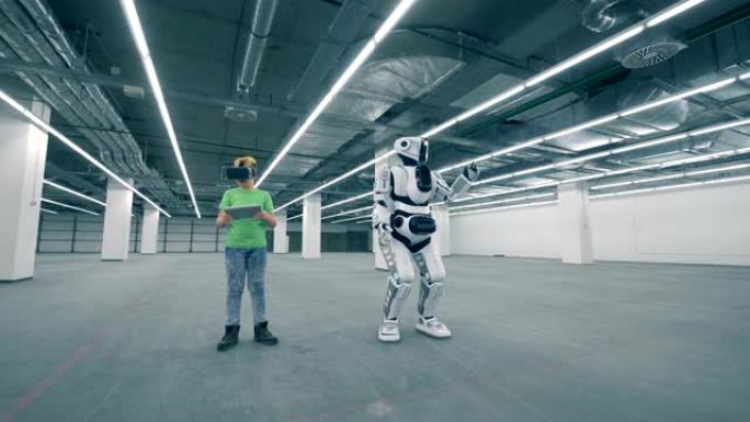 VR眼镜中的小学生使用平板电脑控制机器人，特写镜头。