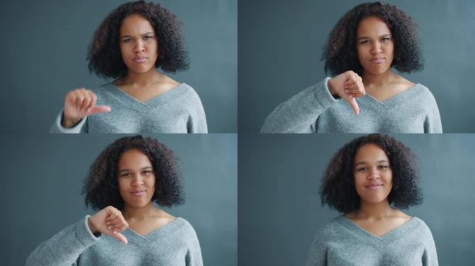 美丽的非裔美国女孩的肖像表现出拇指朝下的手势