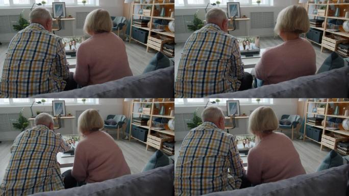 开朗的老人与年轻夫妇聊天，在家中用笔记本电脑进行视频通话