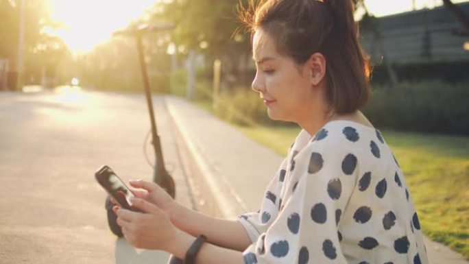 亚洲旅游女子使用手机通过app解锁电动滑板车