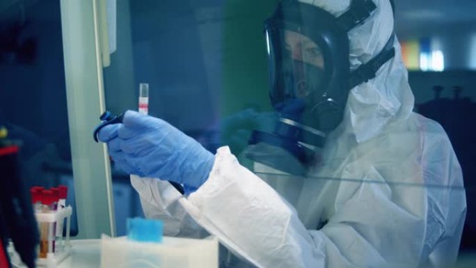 冠状病毒新型冠状病毒肺炎概念。一个穿着防溅服的女人正在实验室里用试管工作