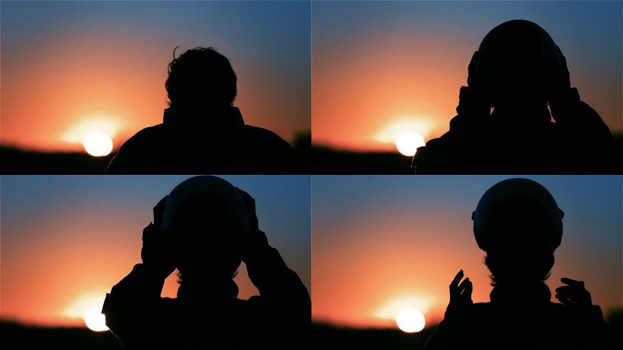 飞行员在日落时戴上头盔。使命概念。