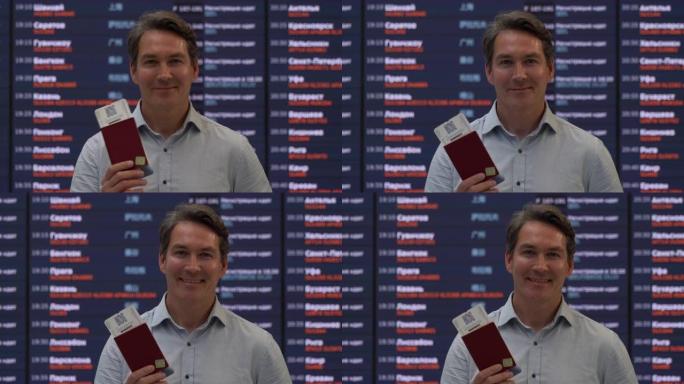 高加索人开朗的男子拿着护照和登机牌，面对机场微笑的镜头