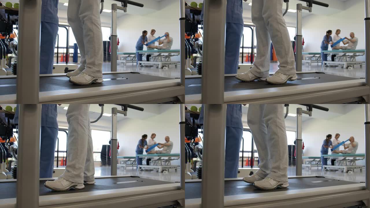 在物理治疗师旁边的跑步机上锻炼无法识别的患者的特写