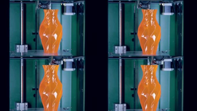 在3D打印机上打印的橙色花瓶。