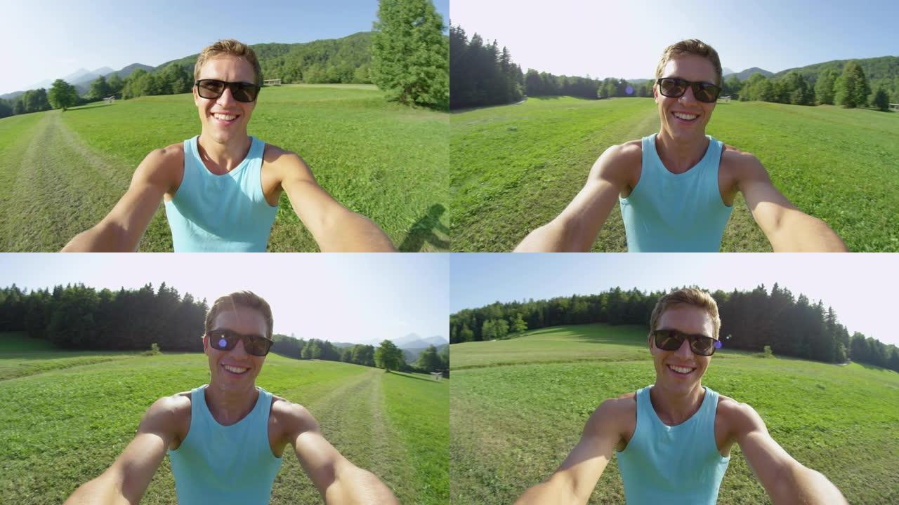 慢动作: 戴着墨镜的微笑男子在阳光明媚的草地上旋转。