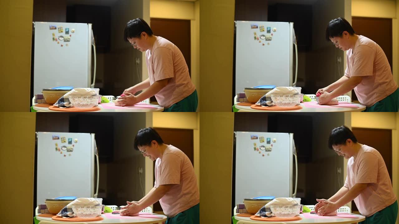 一位亚洲华人待在家里的母亲正在准备面团