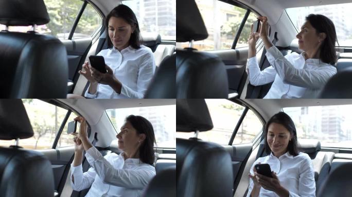 女商人在出租车上用智能手机拍照