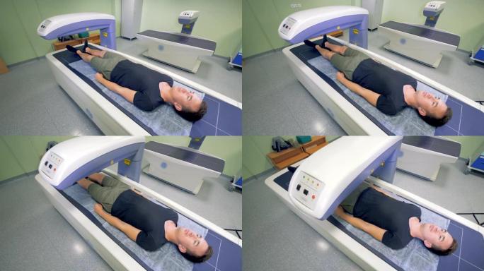 一个成年男子正在被医疗机器扫描。X射线检查。