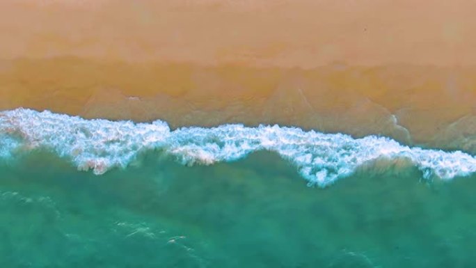 热带沙滩度假海滩的俯视图。慢动作中的海浪。空中4k视图