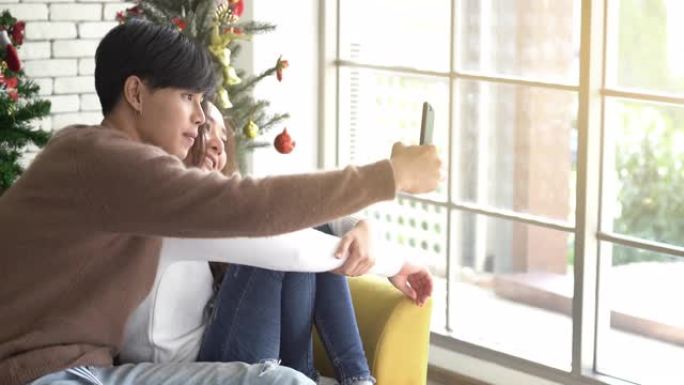 平移射击年轻的亚洲夫妇庆祝圣诞节假期并进行自拍照