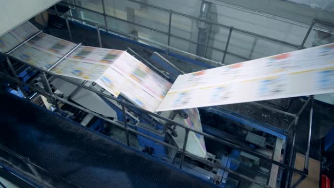 印刷办公室输送机与报纸、自动化机械一起工作。