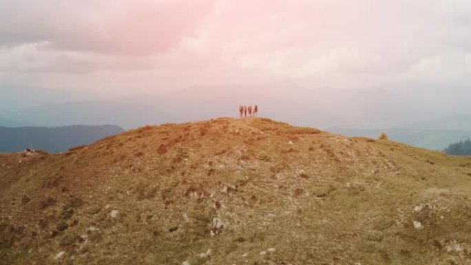 背着背包的四名游客站在山顶上