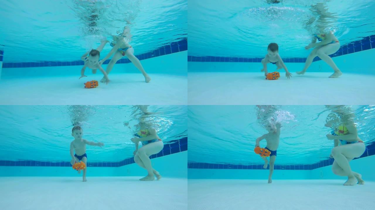 一个在游泳池里学习潜水的婴儿。蹒跚学步的孩子在水下游泳。