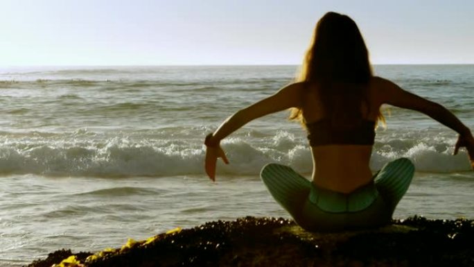 在4k海滩上表演瑜伽的女性