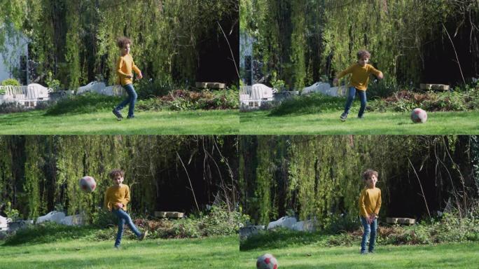 小男孩在家里的花园里踢足球
