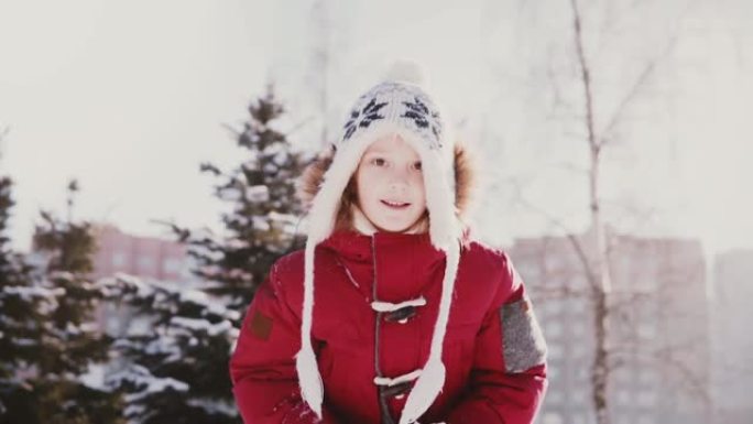 可爱的特写肖像可爱的小高加索女孩穿着冬装向空中扔雪慢动作有趣